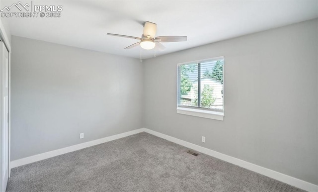 unfurnished room with ceiling fan, carpet floors, visible vents, and baseboards