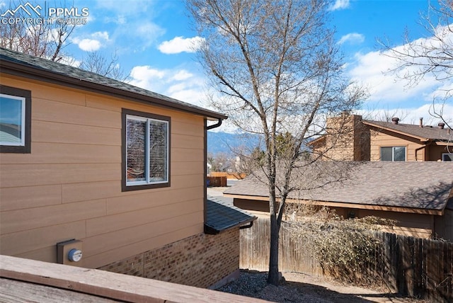 view of side of home featuring fence