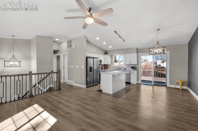 kitchen with stainless steel appliances, dark wood-type flooring, a kitchen island, white cabinetry, and light countertops