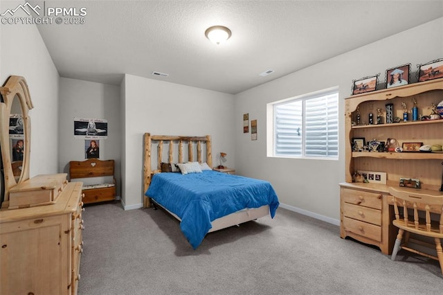 bedroom with light carpet, visible vents, a textured ceiling, and baseboards