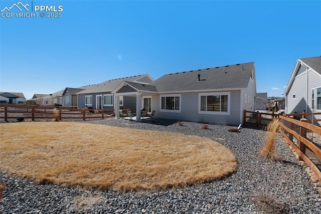 back of house with a patio area, a lawn, a residential view, and a fenced backyard