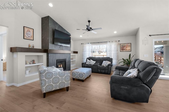 living room with lofted ceiling, recessed lighting, a fireplace, and wood-type flooring