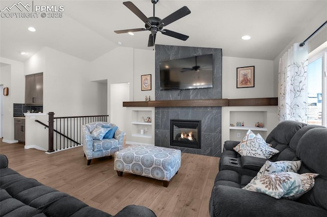 living area featuring a fireplace, vaulted ceiling, recessed lighting, and wood finished floors