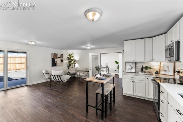 kitchen featuring stainless steel appliances, light countertops, dark wood-type flooring, and backsplash