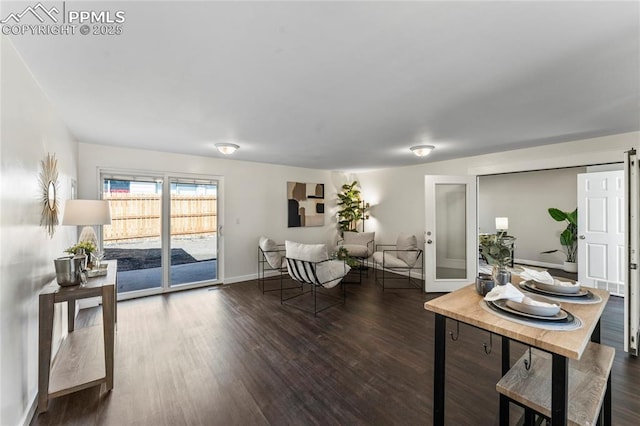 living room featuring dark wood-style flooring and baseboards