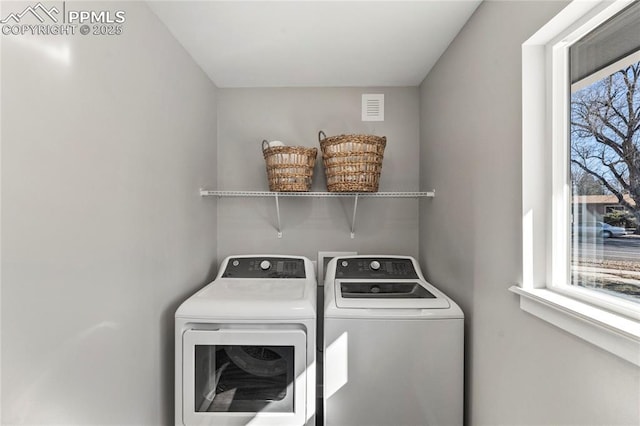 clothes washing area featuring laundry area, washer and clothes dryer, visible vents, and a healthy amount of sunlight