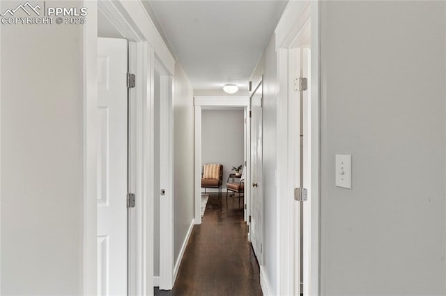 hall with dark wood-type flooring and baseboards