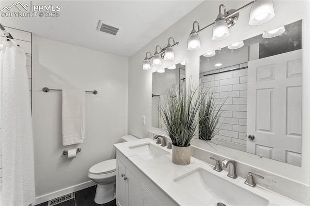 bathroom featuring toilet, visible vents, and a sink