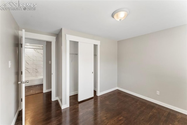 unfurnished bedroom featuring a closet, baseboards, and wood finished floors