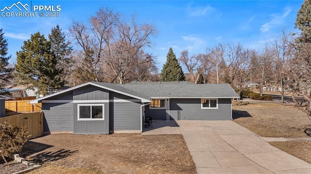 view of front of property with roof with shingles and fence