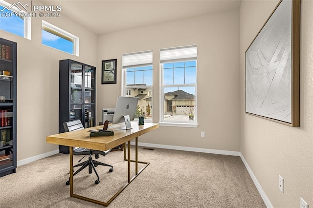 carpeted office with plenty of natural light and baseboards