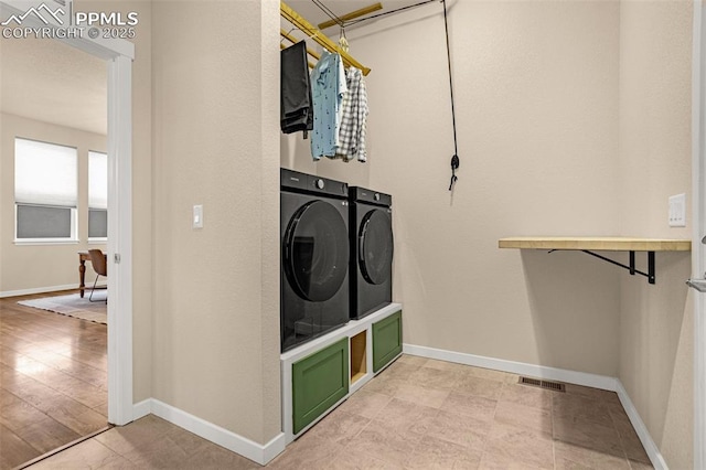 laundry room featuring washer and dryer, laundry area, visible vents, and baseboards