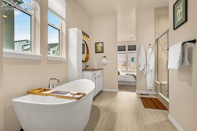 ensuite bathroom featuring a stall shower, a freestanding bath, connected bathroom, and vanity