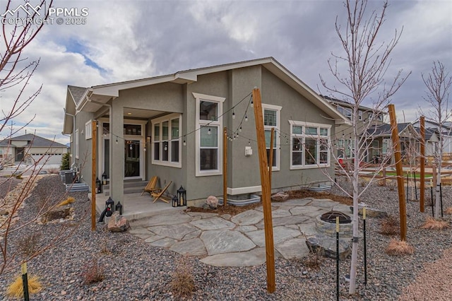 view of front facade featuring entry steps, a patio area, and stucco siding