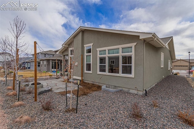 rear view of house with a patio area and stucco siding