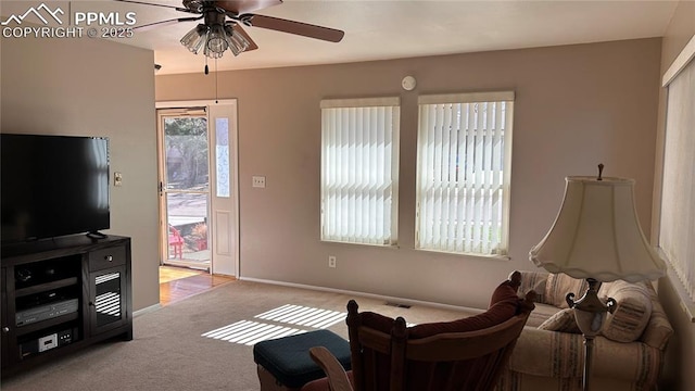 living room with baseboards, visible vents, carpet floors, and ceiling fan