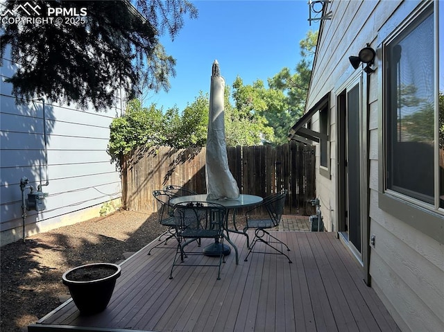 deck featuring outdoor dining area and fence