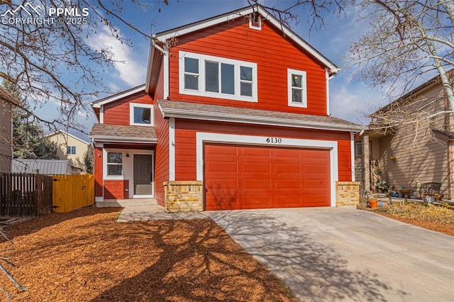 view of front of home with a garage, concrete driveway, and fence