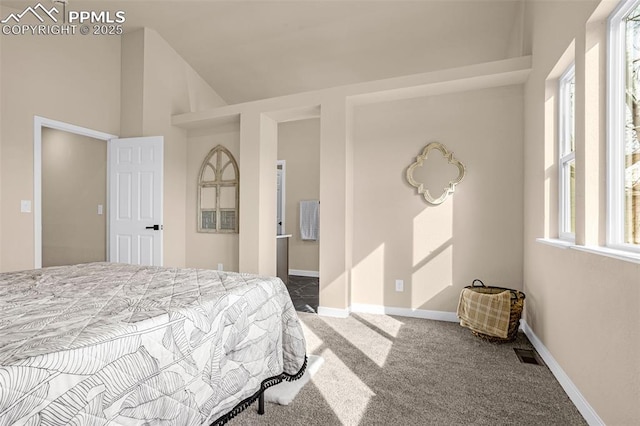 carpeted bedroom featuring baseboards, visible vents, and vaulted ceiling