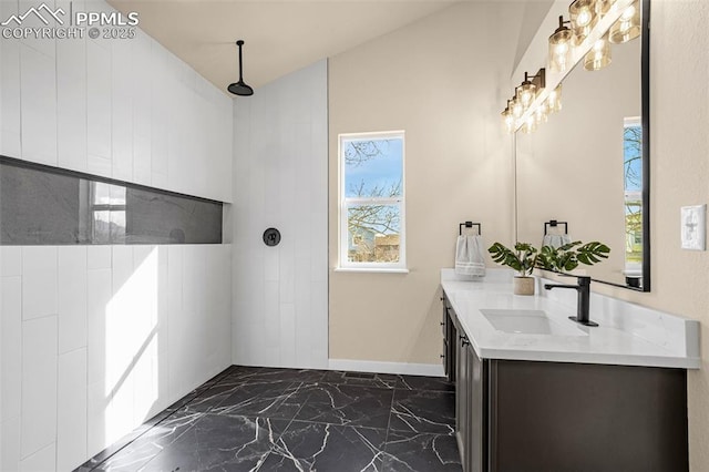 full bathroom with marble finish floor, tiled shower, vanity, and baseboards