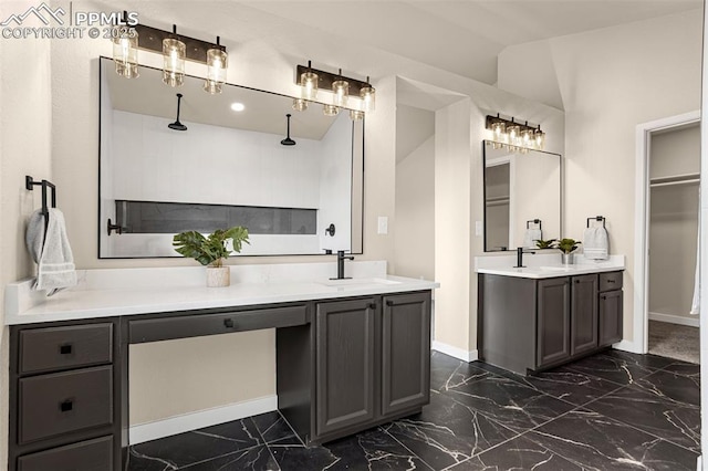 full bathroom with marble finish floor, vanity, and baseboards