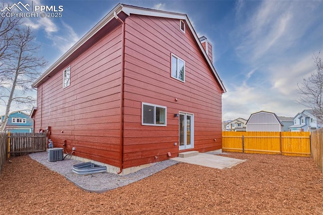 rear view of house featuring central AC and a fenced backyard