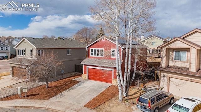 view of front of house featuring solar panels, an attached garage, a residential view, and driveway