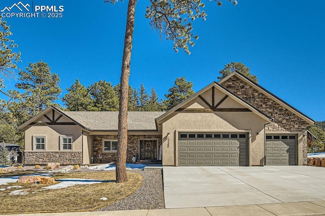 tudor house featuring a garage, stone siding, driveway, and stucco siding