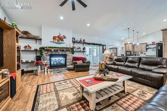 living room featuring recessed lighting, a fireplace, a ceiling fan, vaulted ceiling, and light wood finished floors