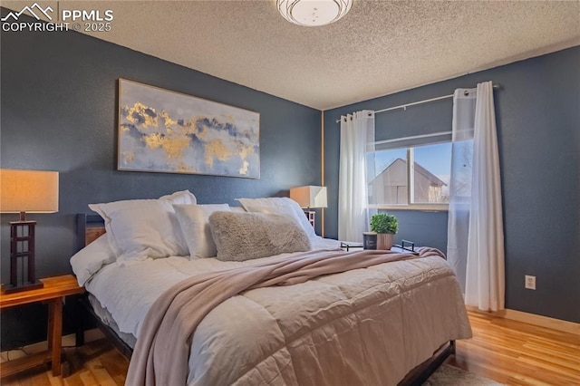 bedroom featuring a textured ceiling and wood finished floors