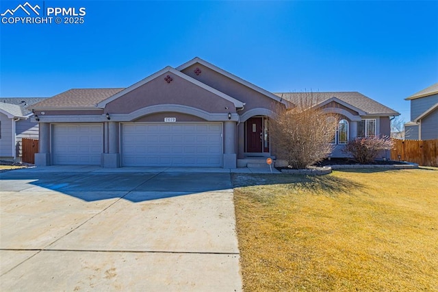 ranch-style house with concrete driveway, an attached garage, fence, a front yard, and stucco siding