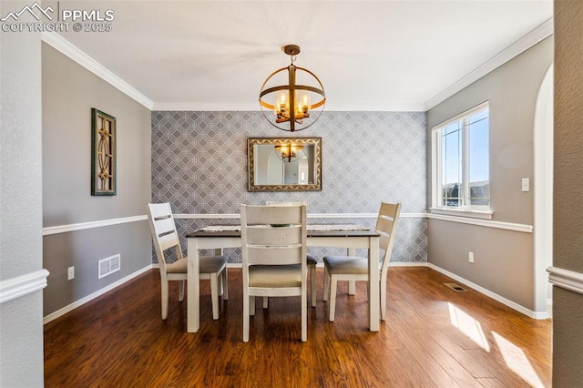 7619 High Gate Dr, Fountain, CO 80817 - dining space with baseboards, an accent wall, ornamental molding, wood finished floors, and a notable chandelier