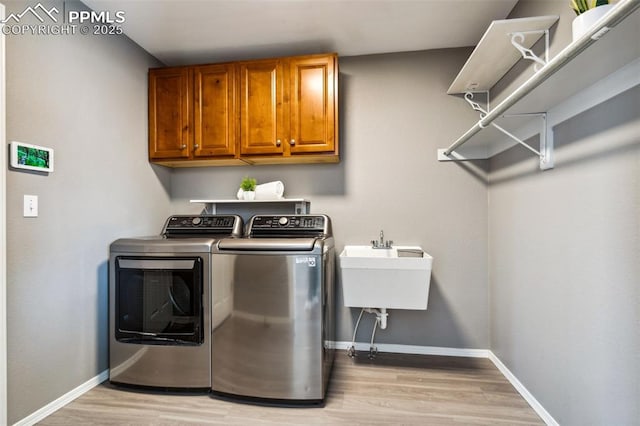 7619 High Gate Dr, Fountain, CO 80817 - laundry room with cabinet space, light wood-style flooring, baseboards, and independent washer and dryer