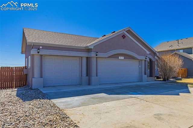 ranch-style house featuring concrete driveway, an attached garage, fence, and stucco siding