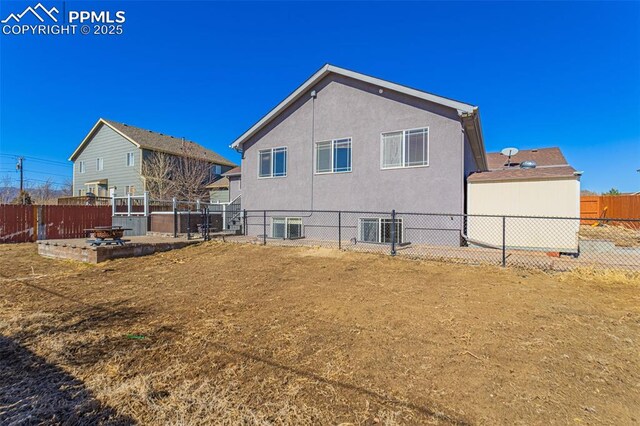 7619 High Gate Dr, Fountain, CO 80817 - rear view of house featuring central AC unit, an outdoor fire pit, a fenced backyard, and stucco siding