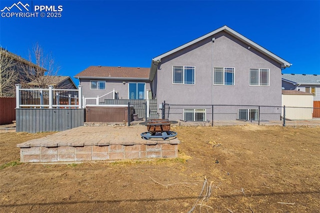 7619 High Gate Dr, Fountain, CO 80817 - rear view of property featuring an outdoor fire pit, fence, a hot tub, and stucco siding