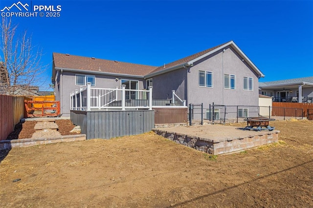 7619 High Gate Dr, Fountain, CO 80817 - rear view of house with a deck, a fenced backyard, a fire pit, and stucco siding