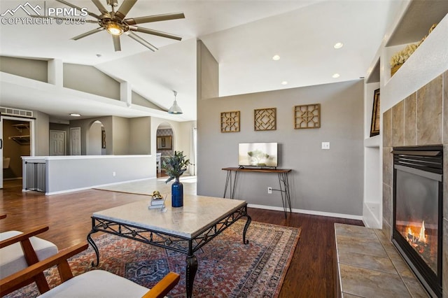 7619 High Gate Dr, Fountain, CO 80817 - living area featuring arched walkways, a tile fireplace, recessed lighting, dark wood-style flooring, and baseboards
