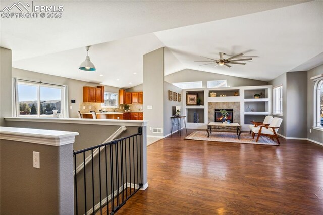 7619 High Gate Dr, Fountain, CO 80817 - living room featuring lofted ceiling, dark wood-type flooring, a ceiling fan, baseboards, and a tiled fireplace