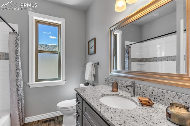 bathroom with visible vents, toilet, vanity, wood finished floors, and baseboards