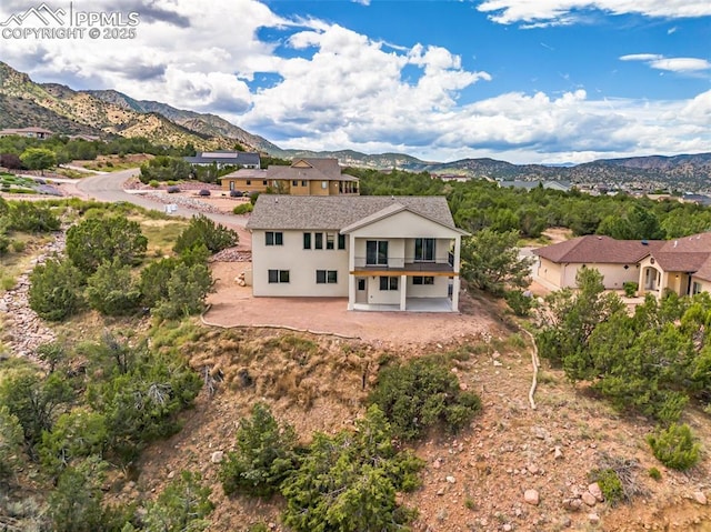 rear view of property featuring a patio, a mountain view, and stucco siding