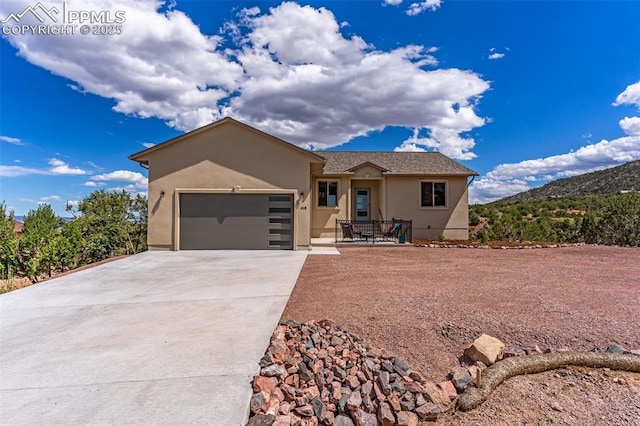 view of front of home with a garage, concrete driveway, and stucco siding