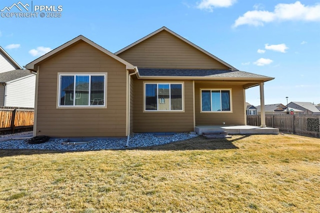 rear view of property with a patio, a lawn, and a fenced backyard