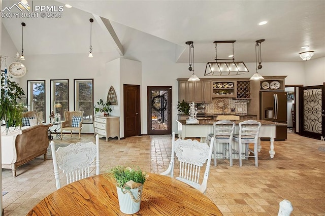 dining space featuring high vaulted ceiling