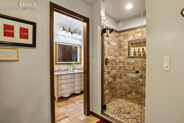 bathroom featuring a sink, a shower stall, and double vanity