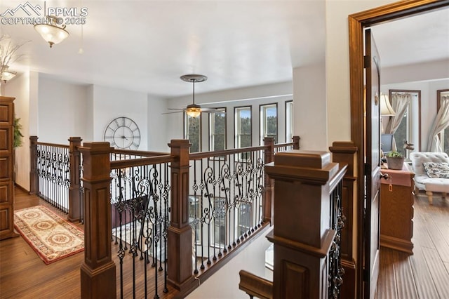 corridor featuring wood finished floors and an upstairs landing