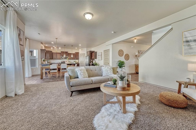 living room with baseboards and light colored carpet