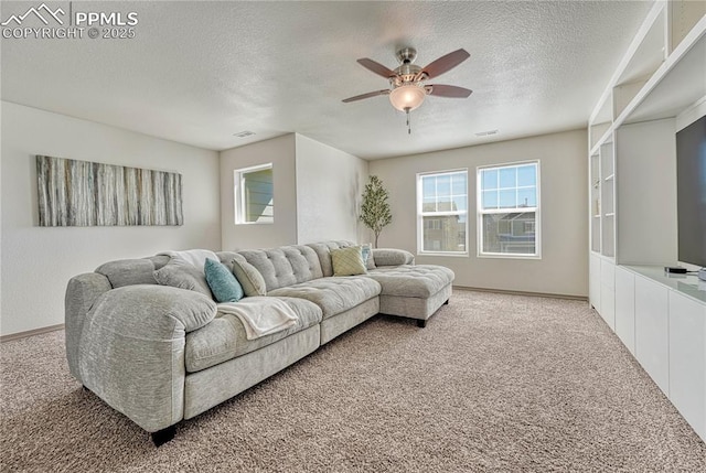 living area with visible vents, light colored carpet, ceiling fan, a textured ceiling, and baseboards