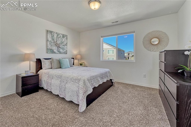 carpeted bedroom with visible vents, a textured ceiling, and baseboards