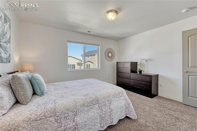 bedroom featuring visible vents, carpet flooring, a textured ceiling, and baseboards